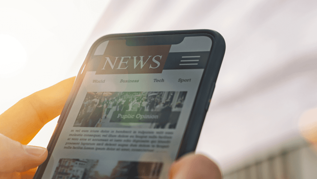 PJ News Ticker: The Secret Weapon for Keeping Up with the Fast-Paced News Cycle! 2 A person holding a smartphone with a PJ news ticker.