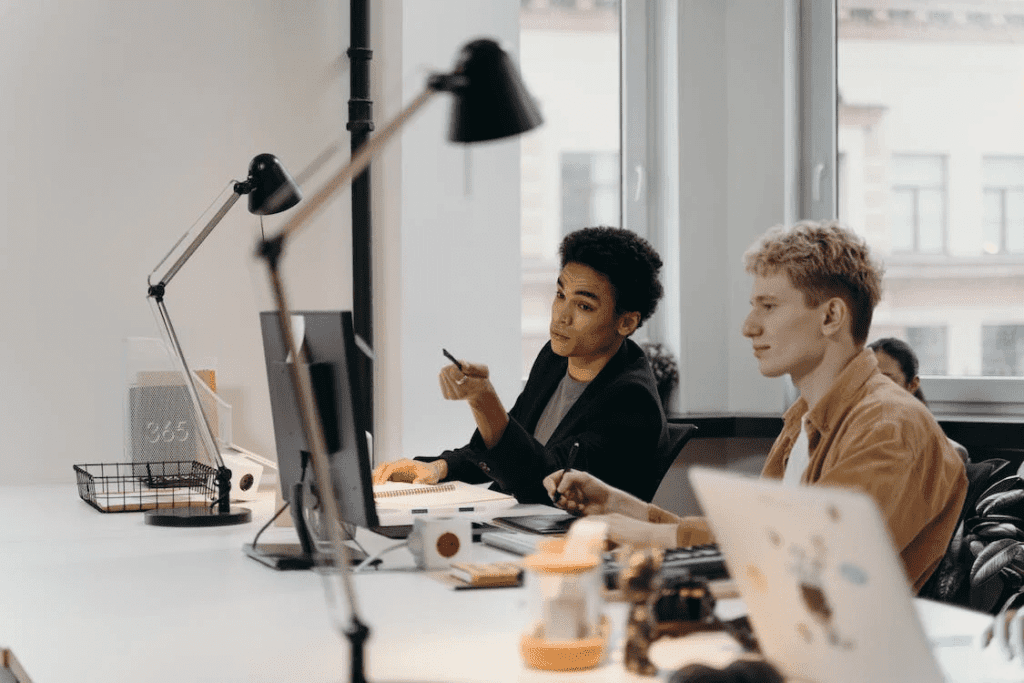 A group of people working at a desk in an office who specialize in WordPress Management Services.