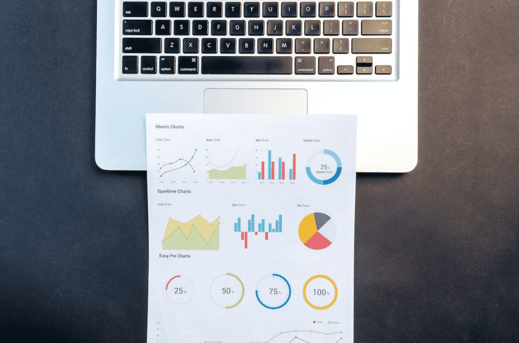 How to Use the Ahrefs WordPress Plugin to Analyze Your Site 4 A laptop on a table with graphs next to it.