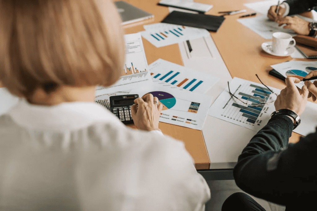 How Much Does it Cost to Maintain A Website Monthly? 2 A group of people sitting around a table discussing the monthly cost of maintaining a website.