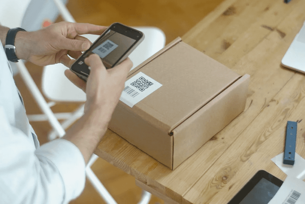 7 Essential Tips for Setting Up a WooCommerce for Service Business 2 A man is using a cell phone to scan a WooCommerce qr code on a box.
