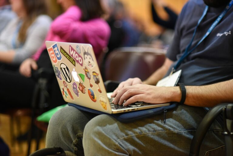 Affordable WordPress Maintenance Plans for Your Website by WP Experts 9 Person taking notes on a laptop at a WordCamp.
